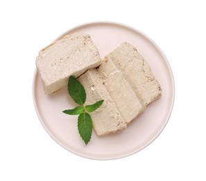 Photo of Plate with pieces of tasty halva and mint isolated on white, top view