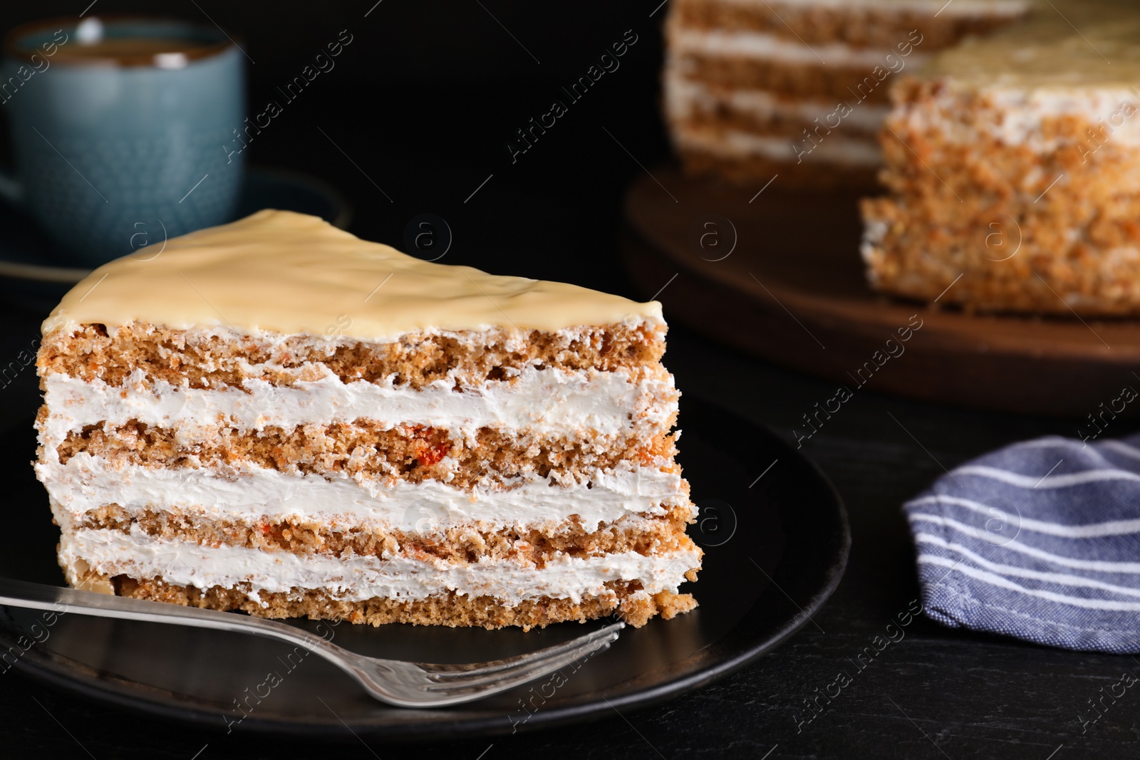 Photo of Delicious cake with condensed milk on black table, closeup