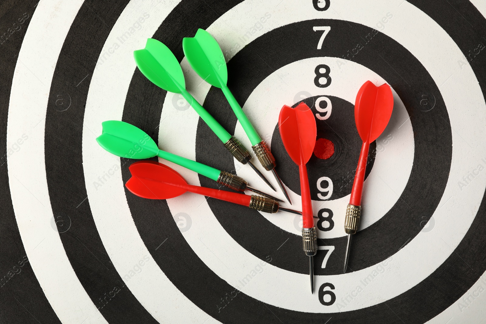 Photo of Red and green arrows on dart board, top view