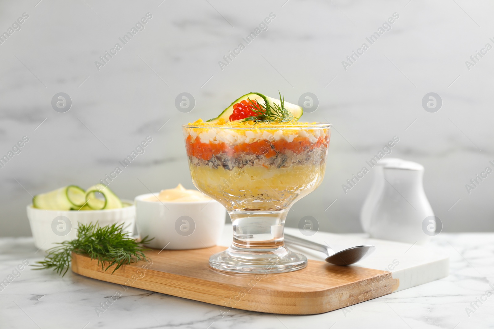 Photo of Traditional russian salad Mimosa served on white marble table
