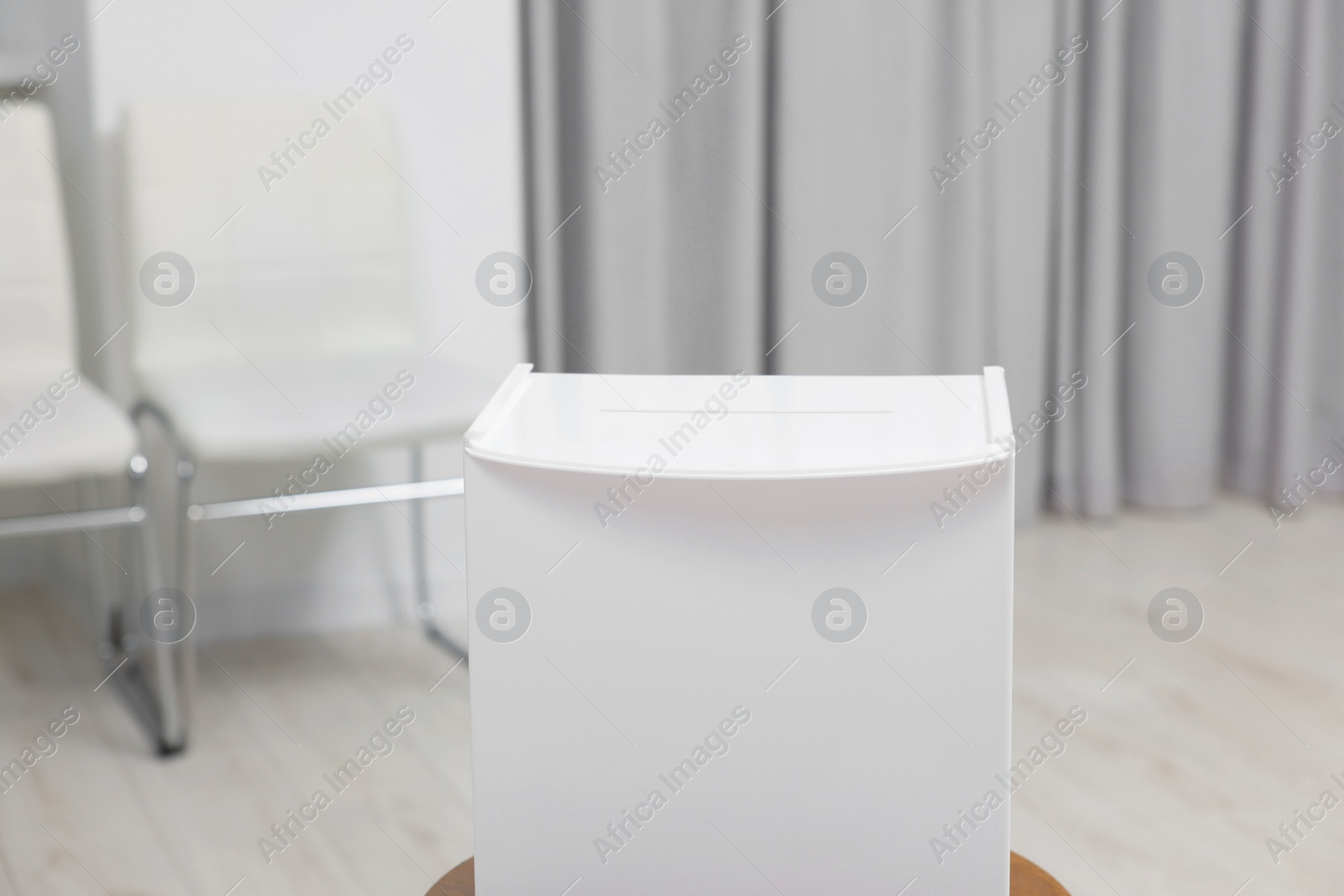 Photo of White ballot box on blurred background, closeup