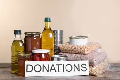 Card with word Donations and different products on wooden table