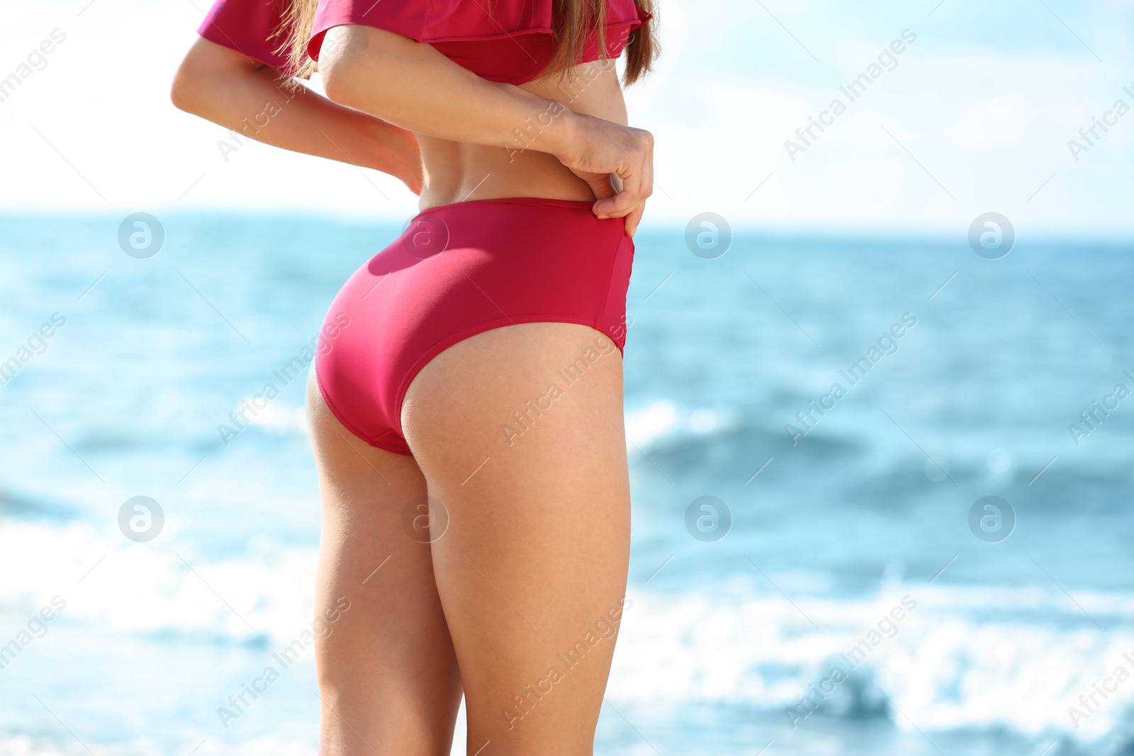 Photo of Attractive young woman in beautiful bikini swimsuit on beach, closeup