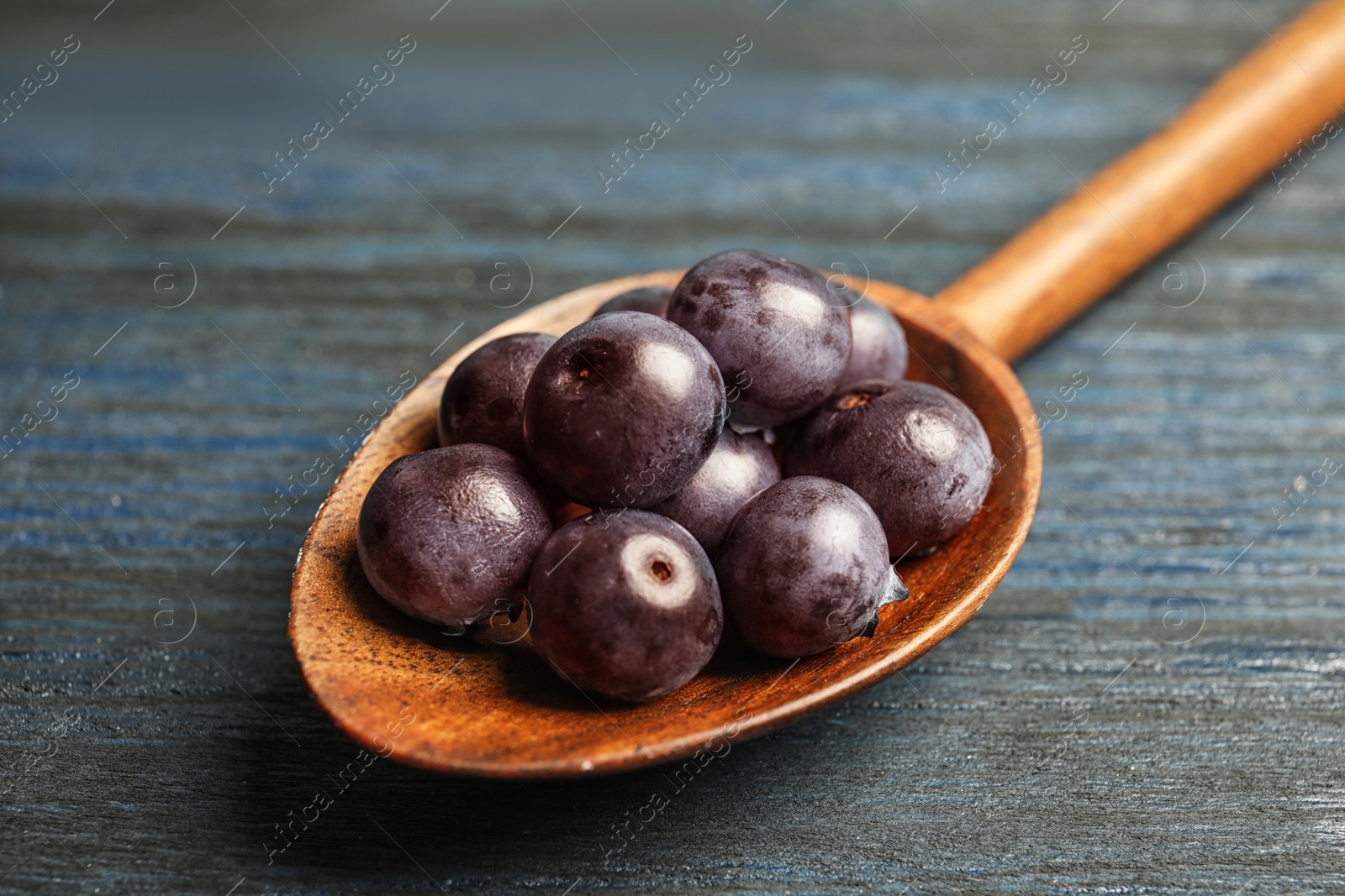 Photo of Spoon with fresh acai berries, closeup