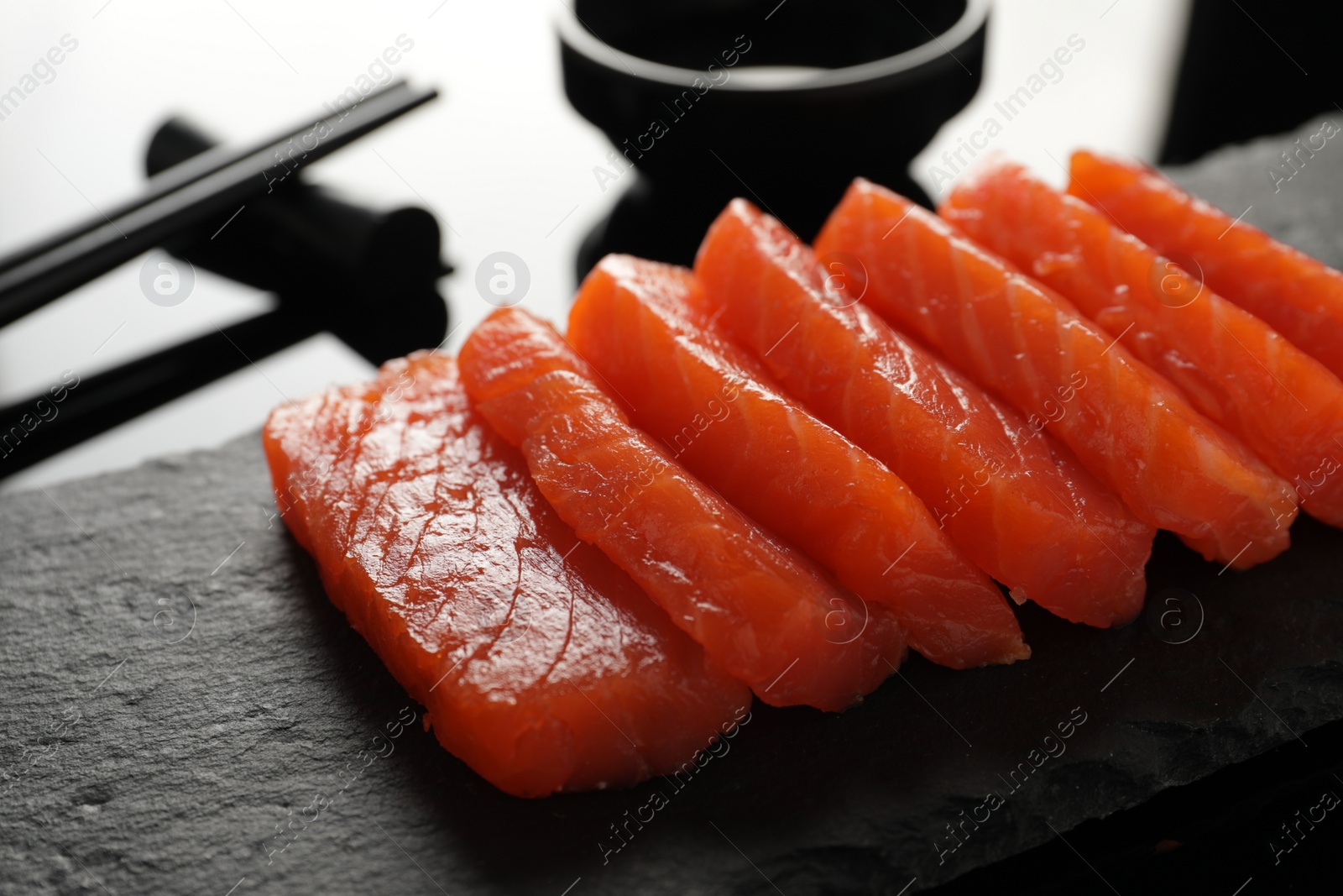 Photo of Delicious salmon sashimi on black table, closeup