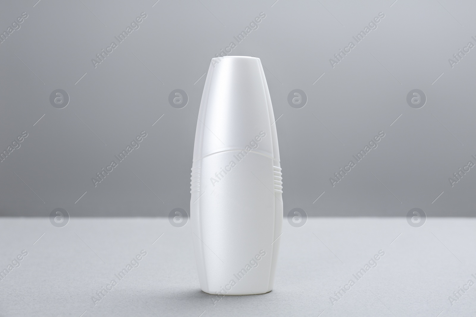 Photo of Bottle with insect repellent spray on grey background