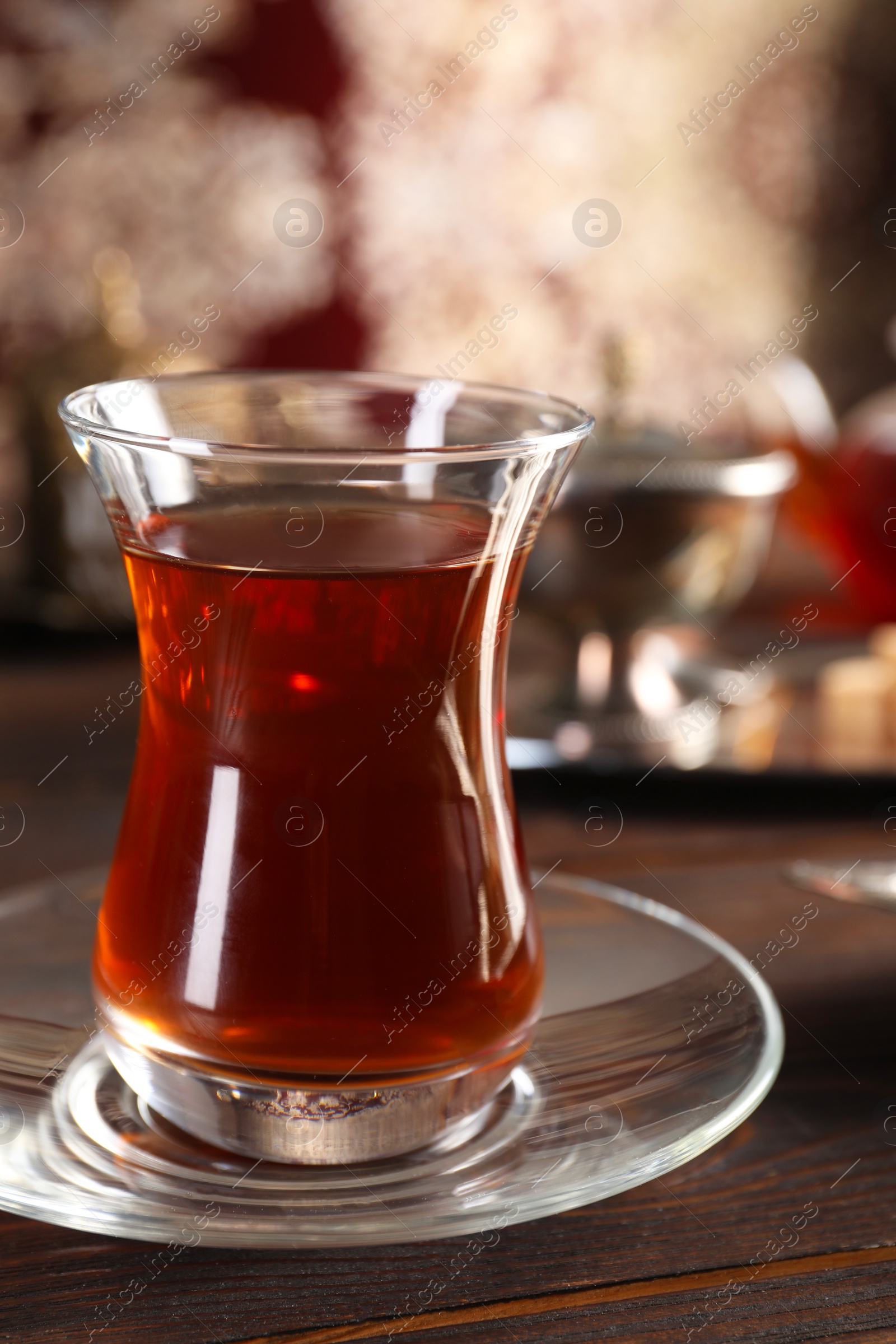 Photo of Traditional Turkish tea in glass on wooden table, closeup