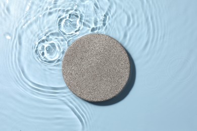 Photo of Presentation for product. Stone podium in water on light blue background, top view