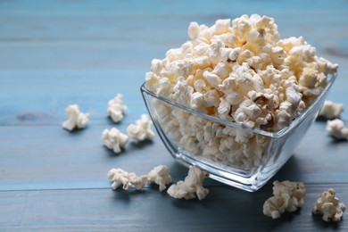 Photo of Tasty popcorn on light blue wooden table
