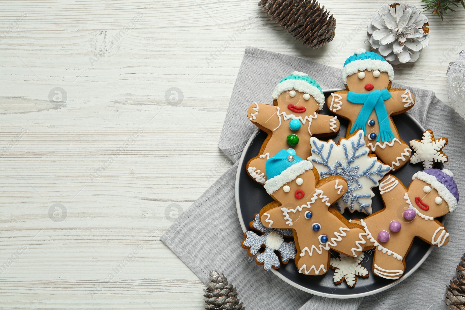 Photo of Delicious Christmas cookies and pine cones on white wooden table, flat lay. Space for text