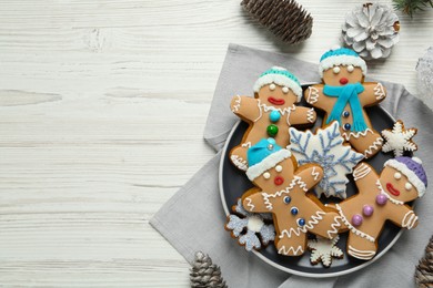 Delicious Christmas cookies and pine cones on white wooden table, flat lay. Space for text