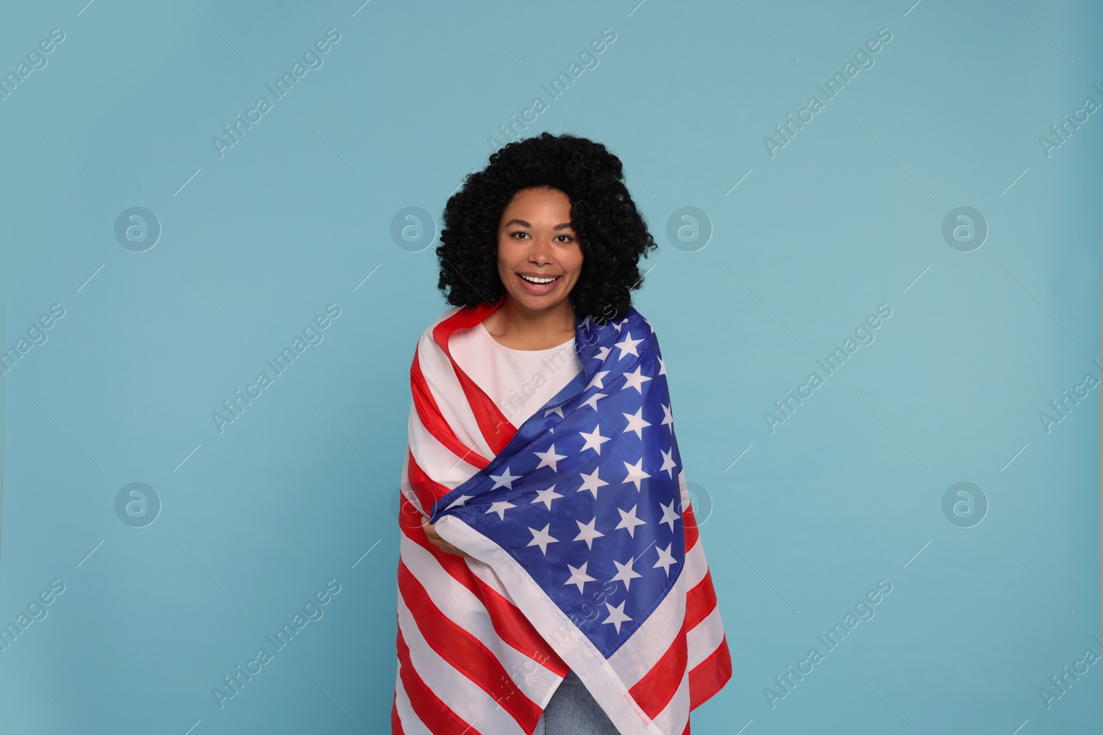 Photo of 4th of July - Independence Day of USA. Happy woman with American flag on light blue background