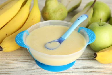 Photo of Baby food in bowl and fresh ingredients on white wooden table