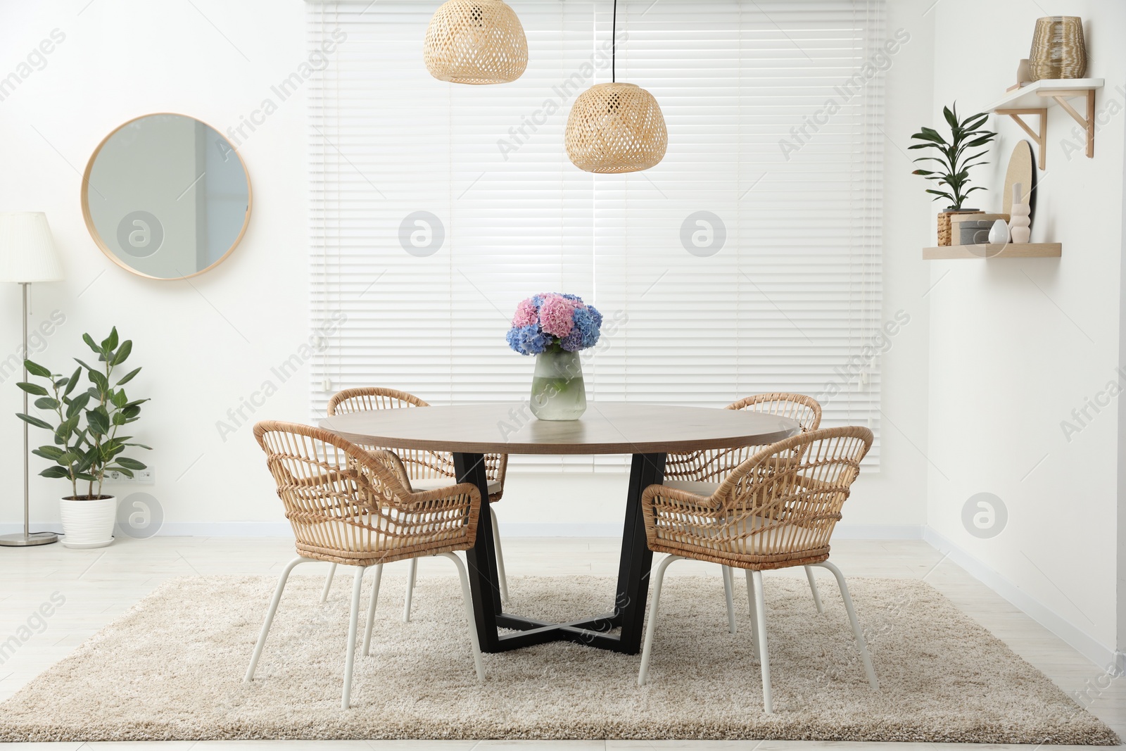 Photo of Table, chairs and vase of hydrangea flowers in dining room. Stylish interior