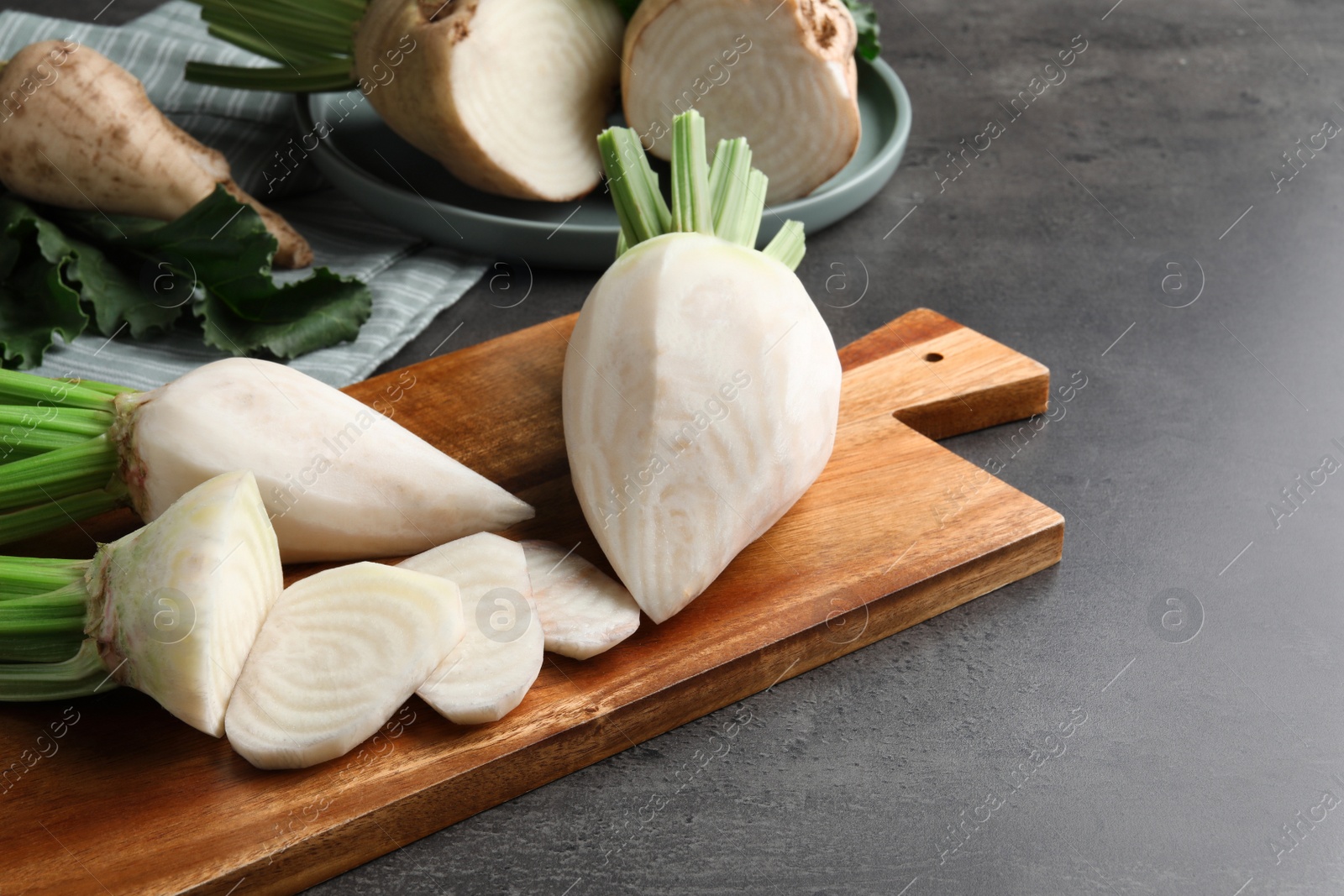 Photo of Peeled and cut sugar beets on grey table. Space for text