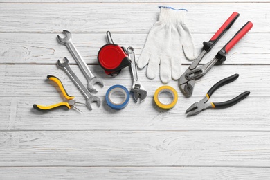 Flat lay composition with plumber's tools and space for text on wooden background