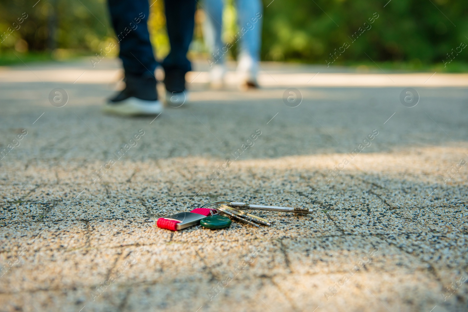 Photo of Men walking outside, focus on lost keys