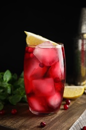 Photo of Tasty refreshing cranberry cocktail and fresh ingredients on wooden table