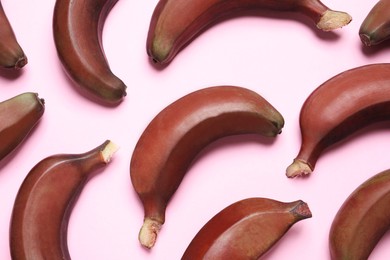 Tasty red baby bananas on pink background, flat lay