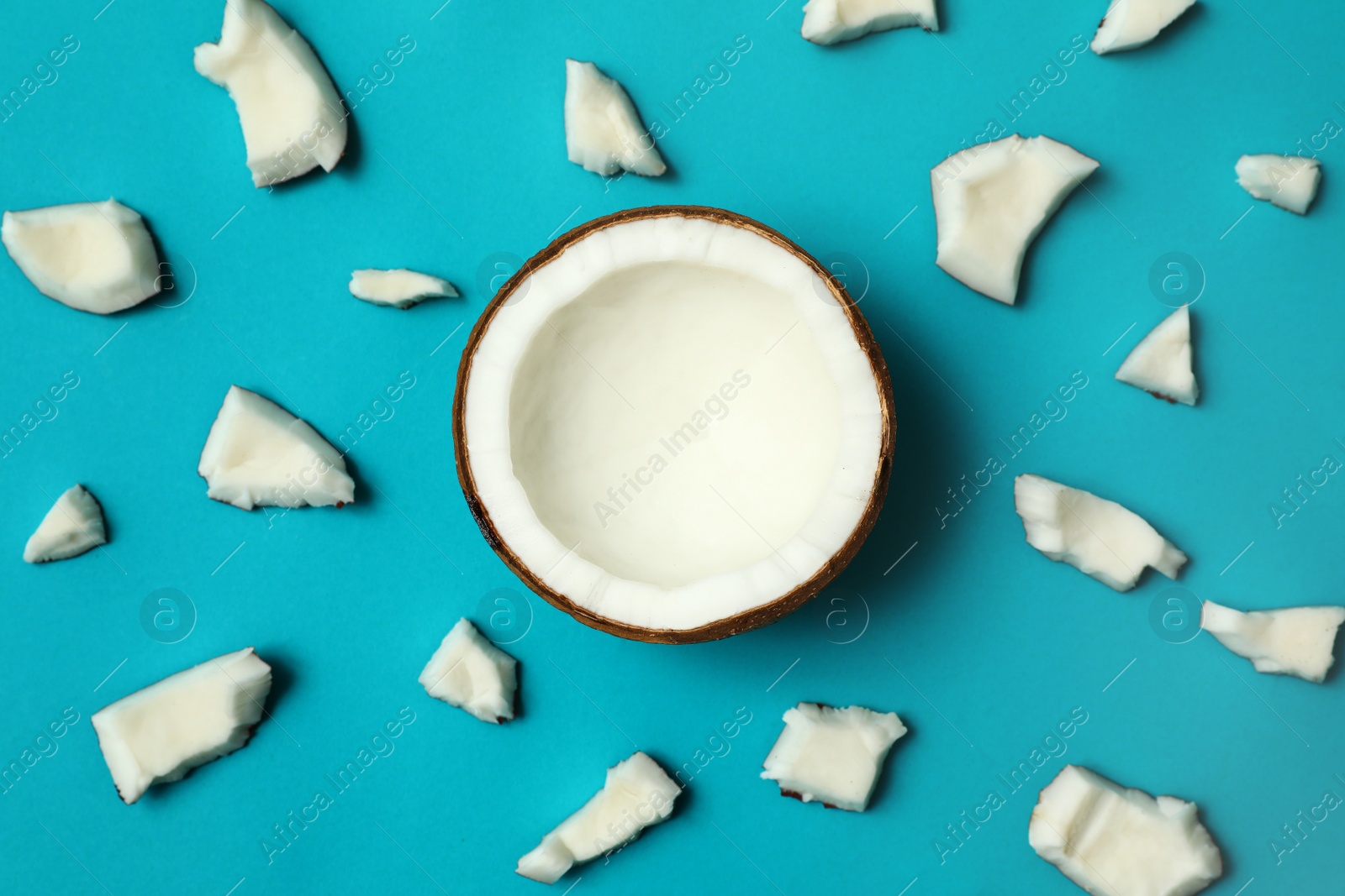 Photo of Fresh coconut pieces on blue background, flat lay