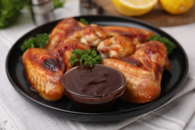 Fresh marinade and chicken wings on table, closeup