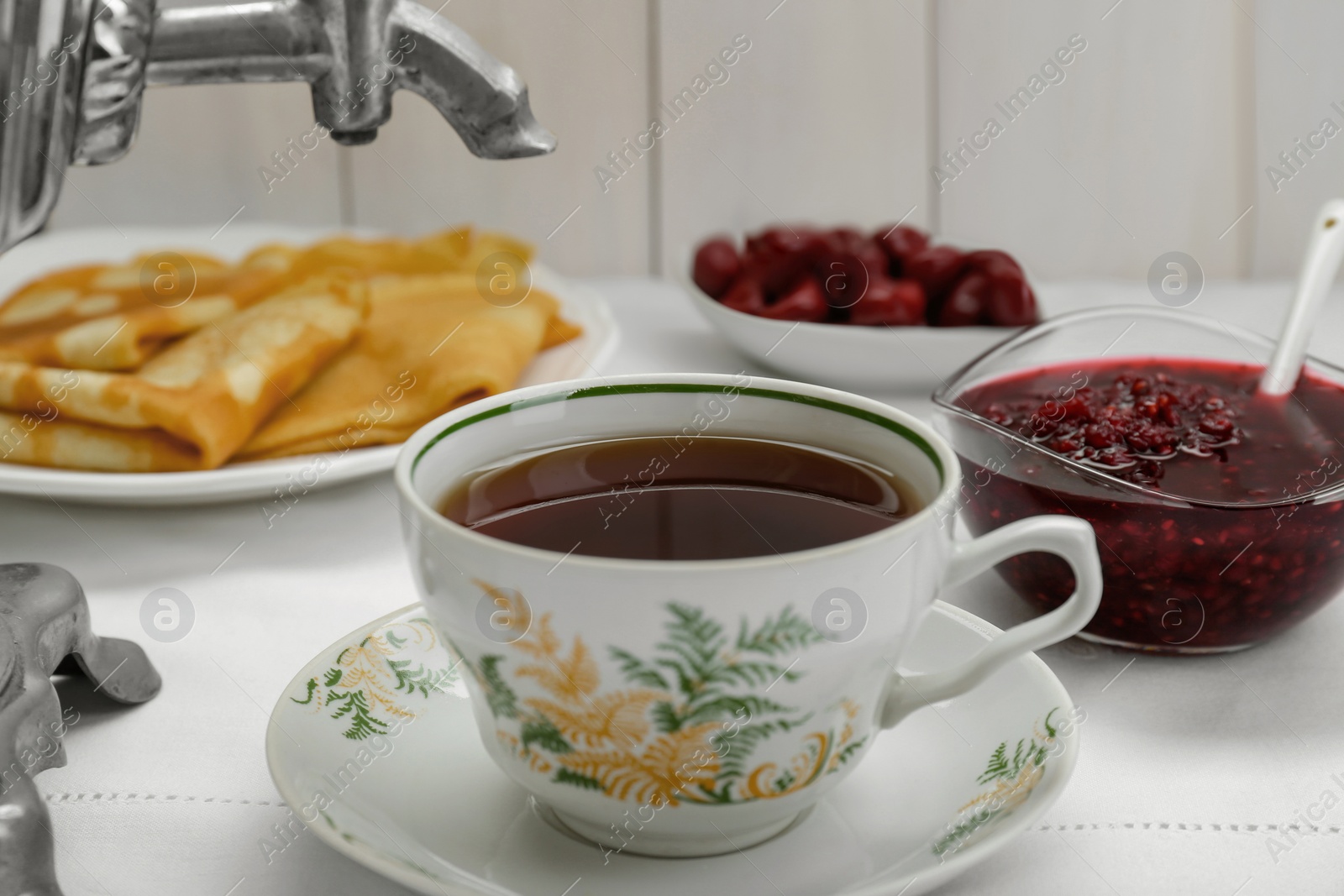 Photo of Cup of aromatic tea and treats on table, closeup