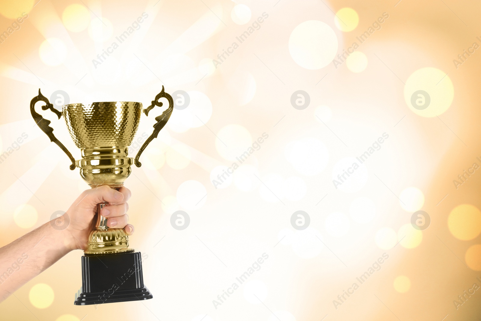 Image of Man holding gold trophy cup on color background, closeup. Space for text