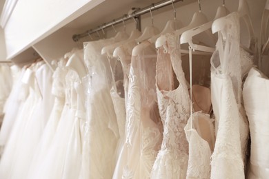 Different wedding dresses on hangers in boutique