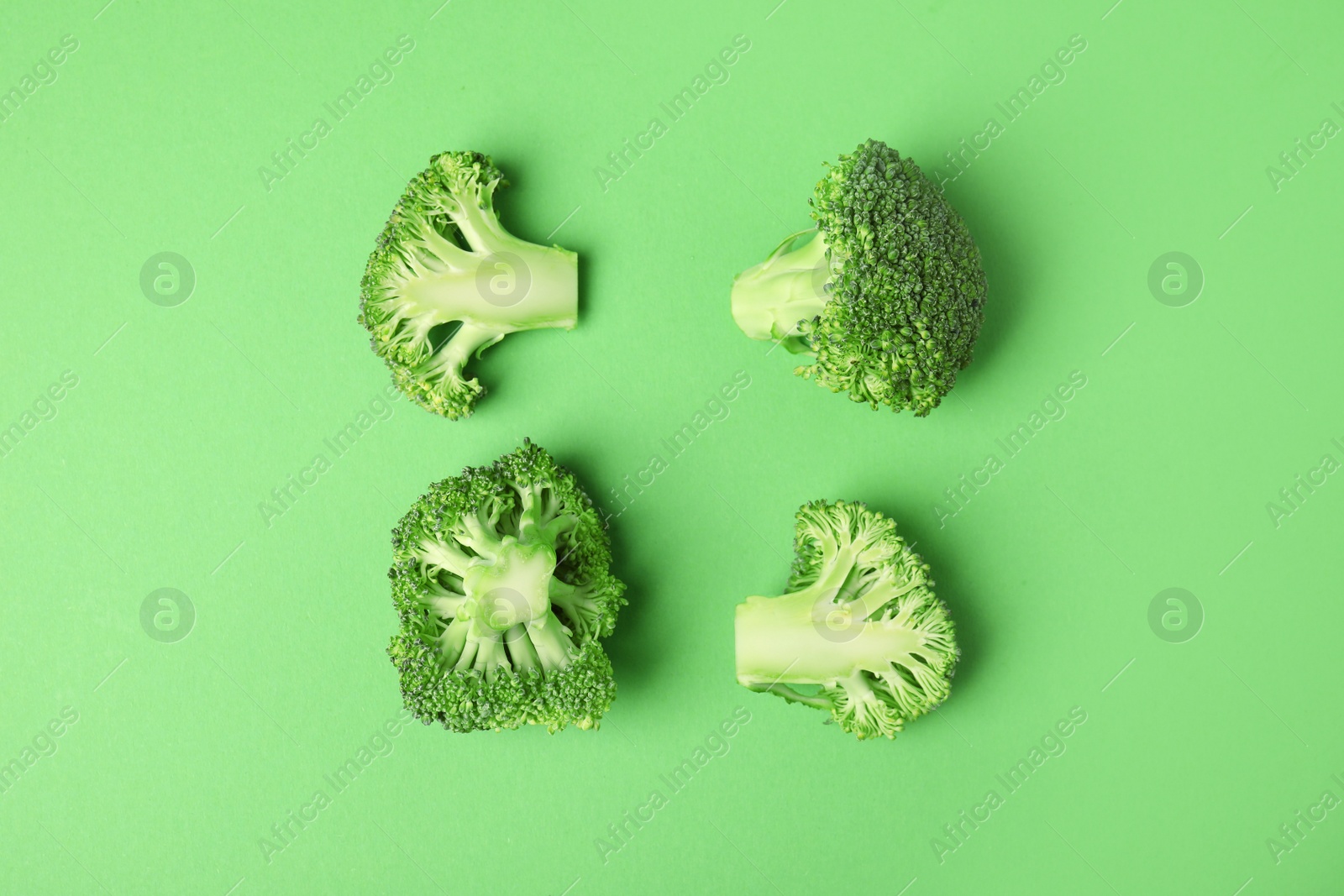 Photo of Flat lay composition with fresh green broccoli on color background