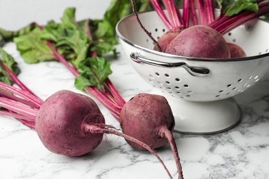 Photo of Raw ripe beets on white marble table