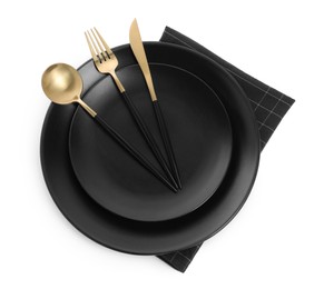 Black plates with cutlery on white background, top view
