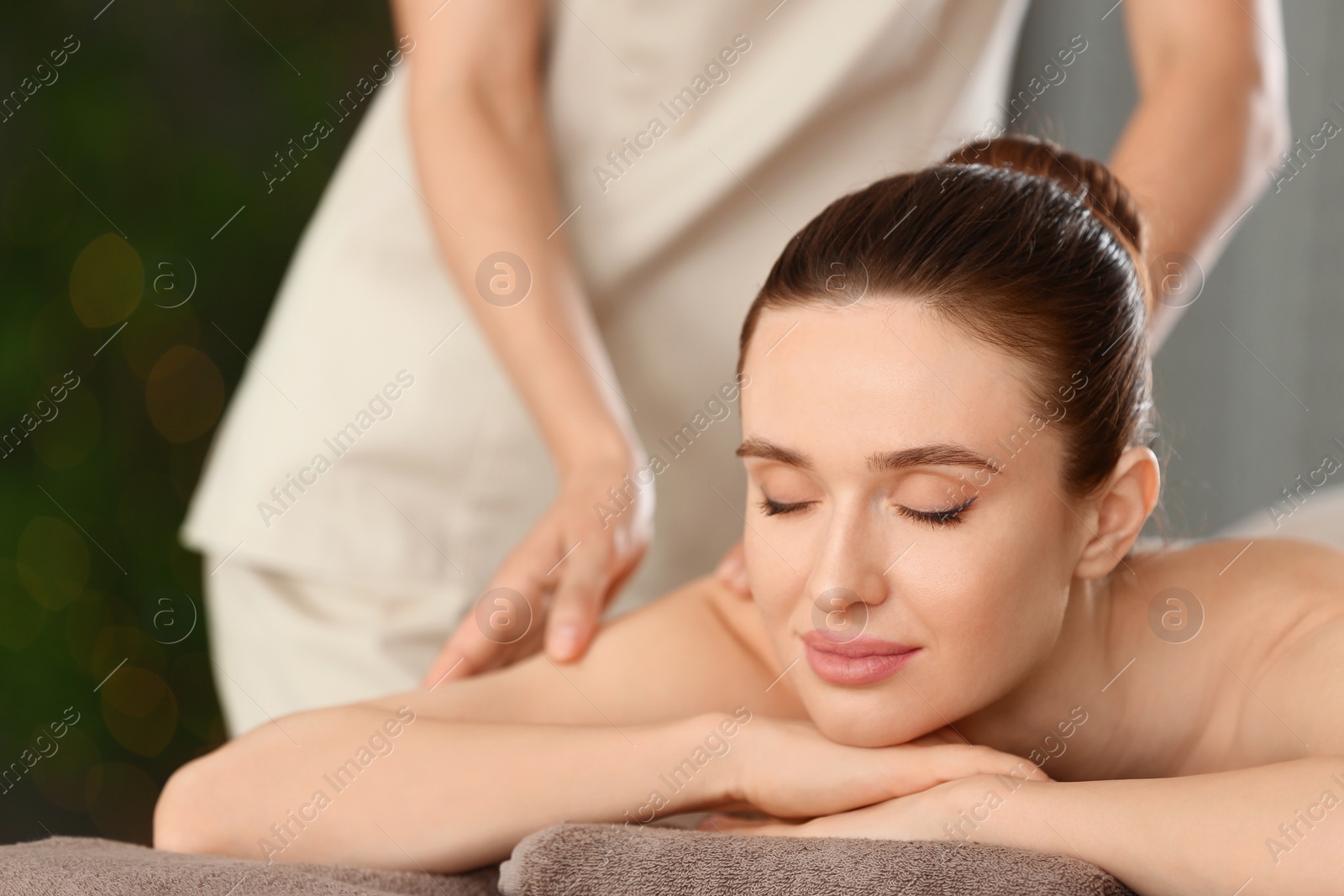 Photo of Beautiful young woman enjoying massage in spa salon