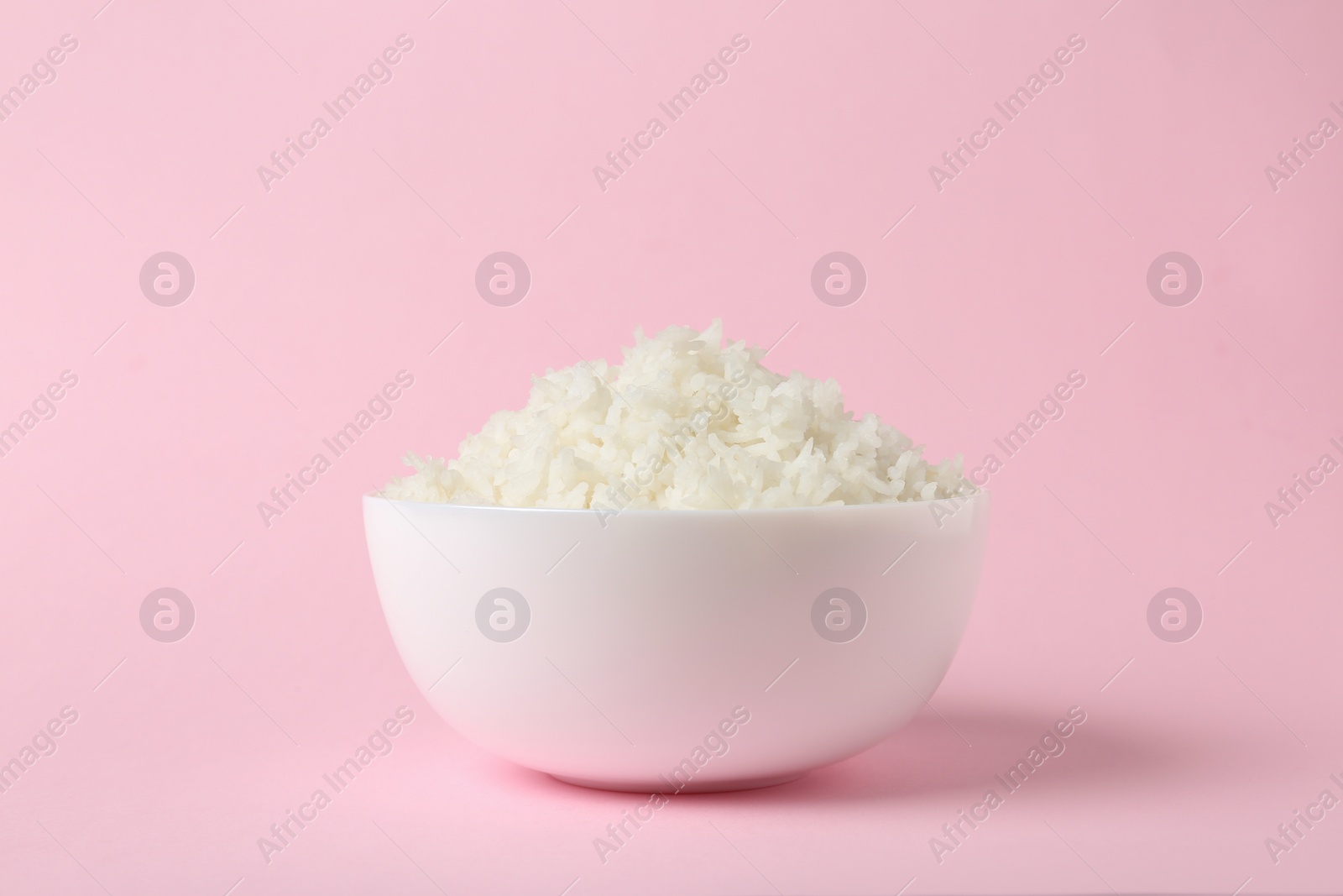 Photo of Bowl of boiled rice on color background