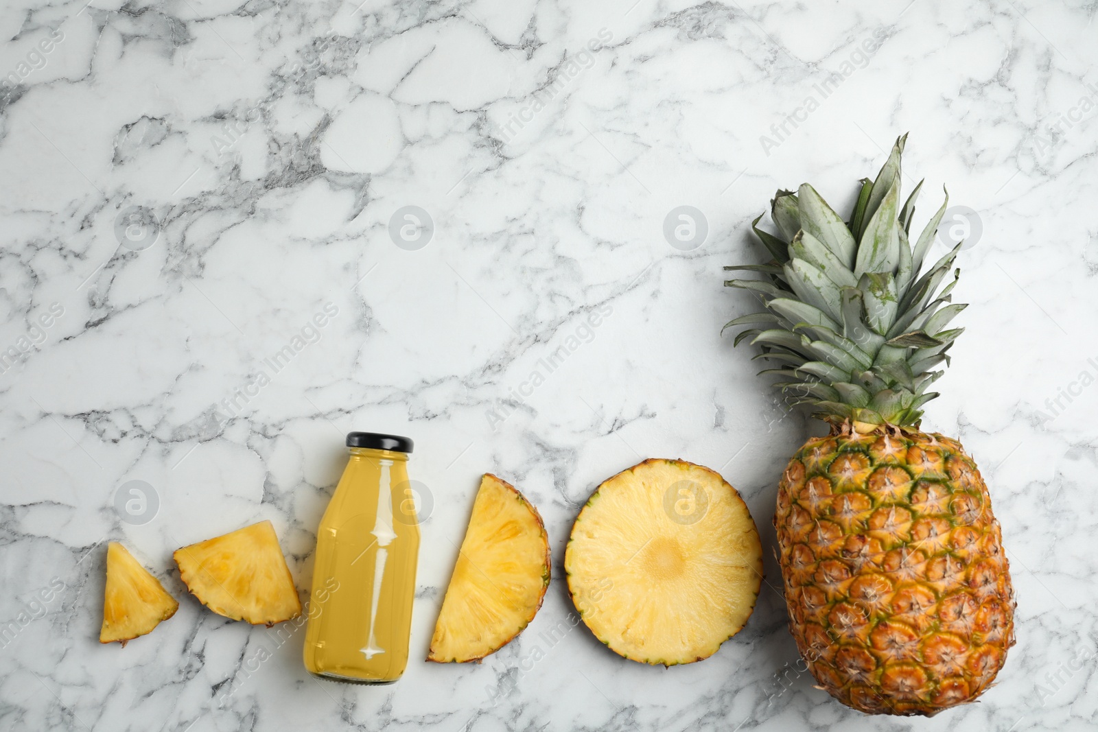 Photo of Delicious pineapple juice and fresh fruit on white marble table, flat lay