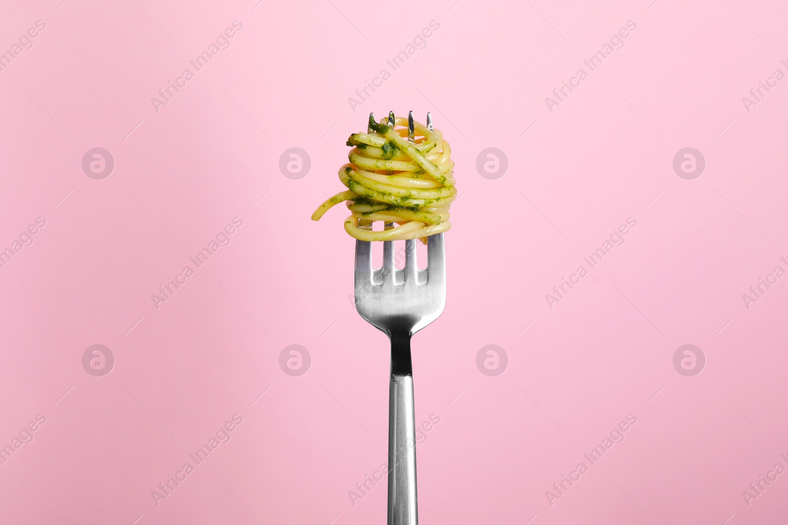 Photo of Fork with tasty pasta on pink background