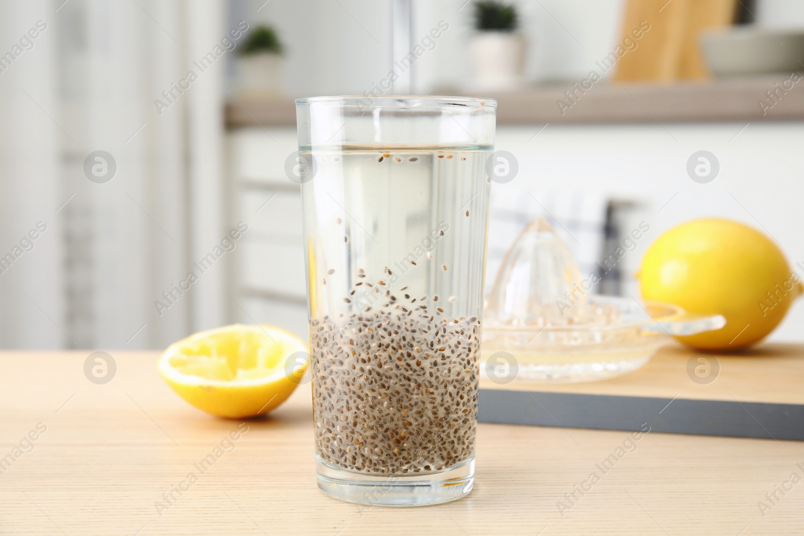 Photo of Composition with glass of water and chia seeds on table against blurred background