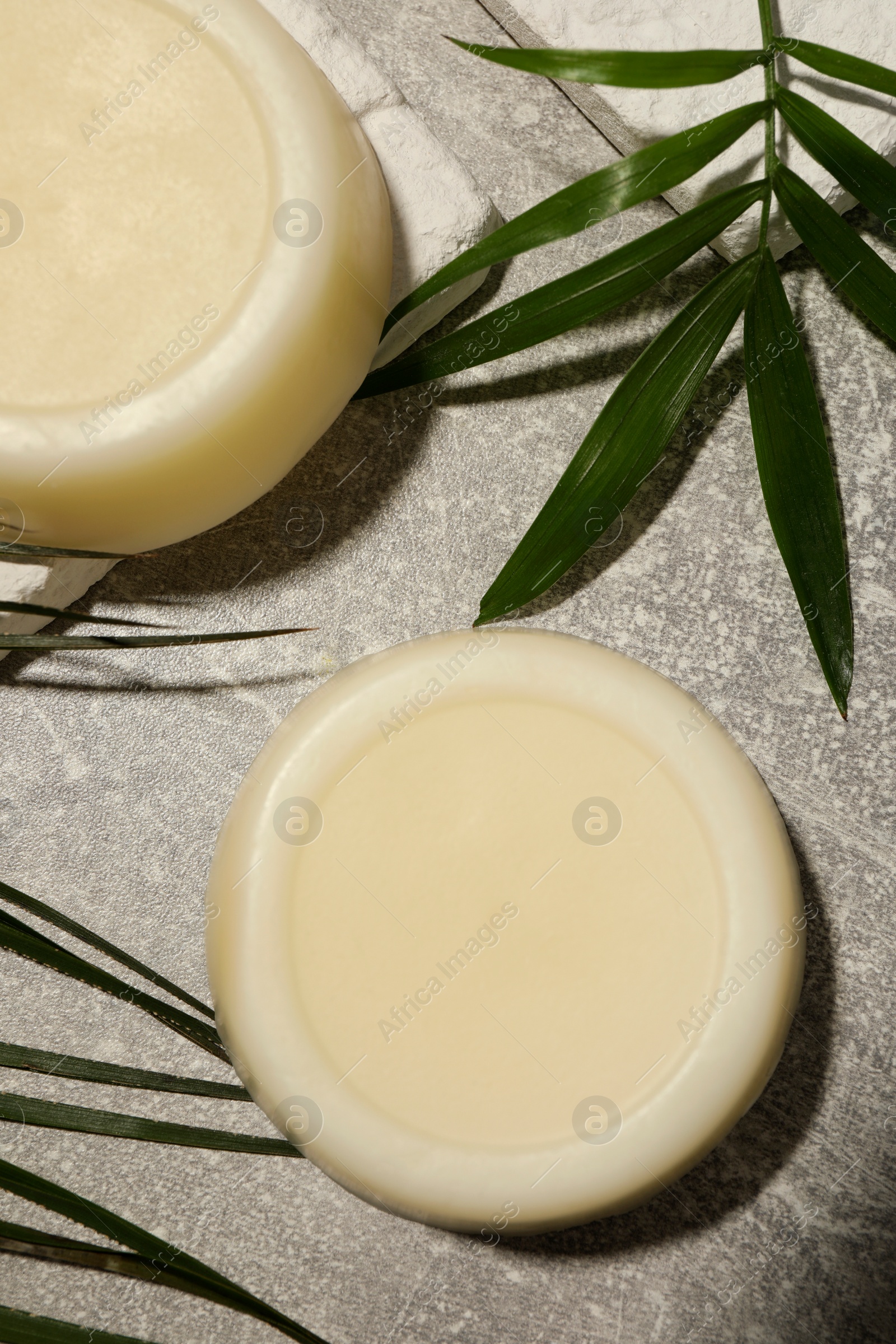 Photo of Flat lay composition of solid shampoo bars and leaf on grey background