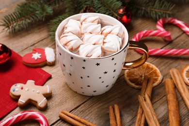 Photo of Delicious hot chocolate with marshmallows and Christmas decor on wooden table