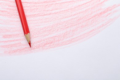 Photo of Red pencil on sheet of paper with drawing, top view