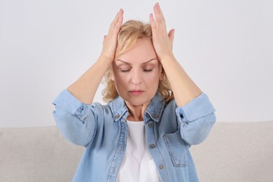 Woman suffering from headache indoors. Hormonal disorders