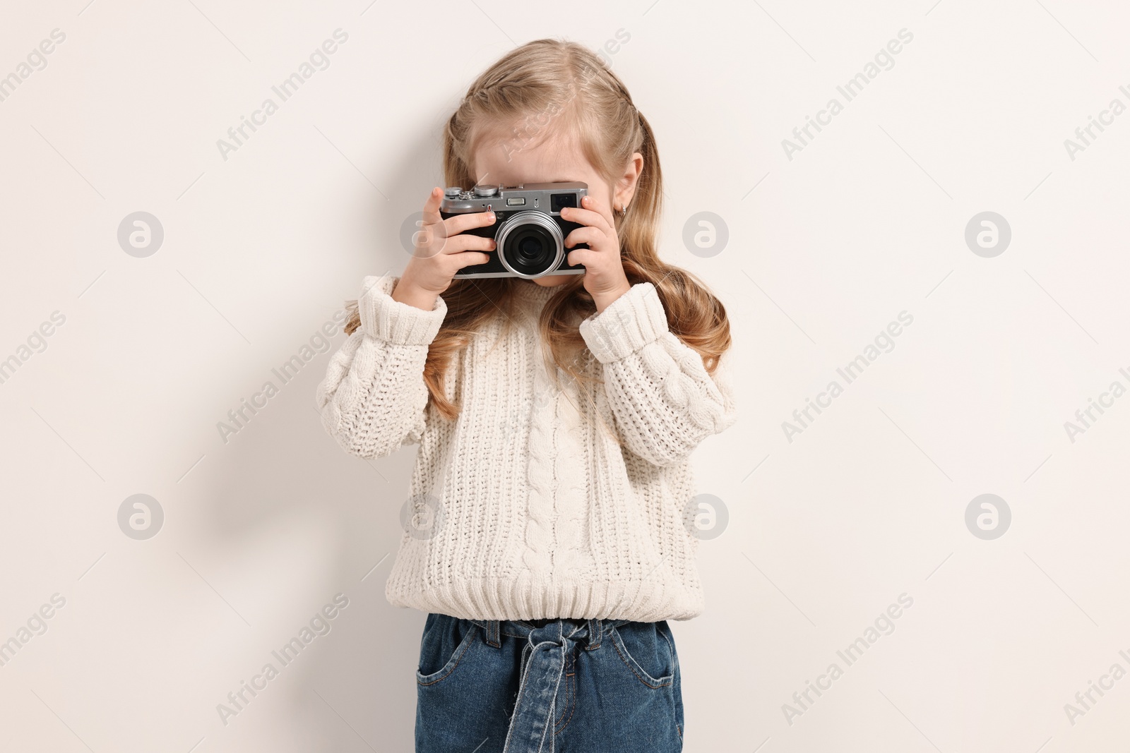 Photo of Fashion concept. Stylish girl with vintage camera on white background