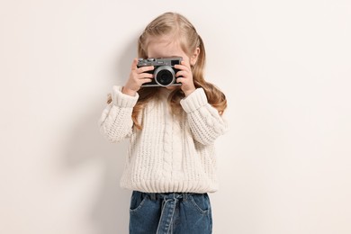 Photo of Fashion concept. Stylish girl with vintage camera on white background