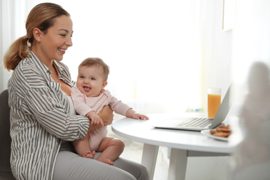 Photo of Young woman with her cute baby at home