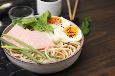 Photo of Delicious ramen with meat on wooden table, closeup with space for text. Noodle soup