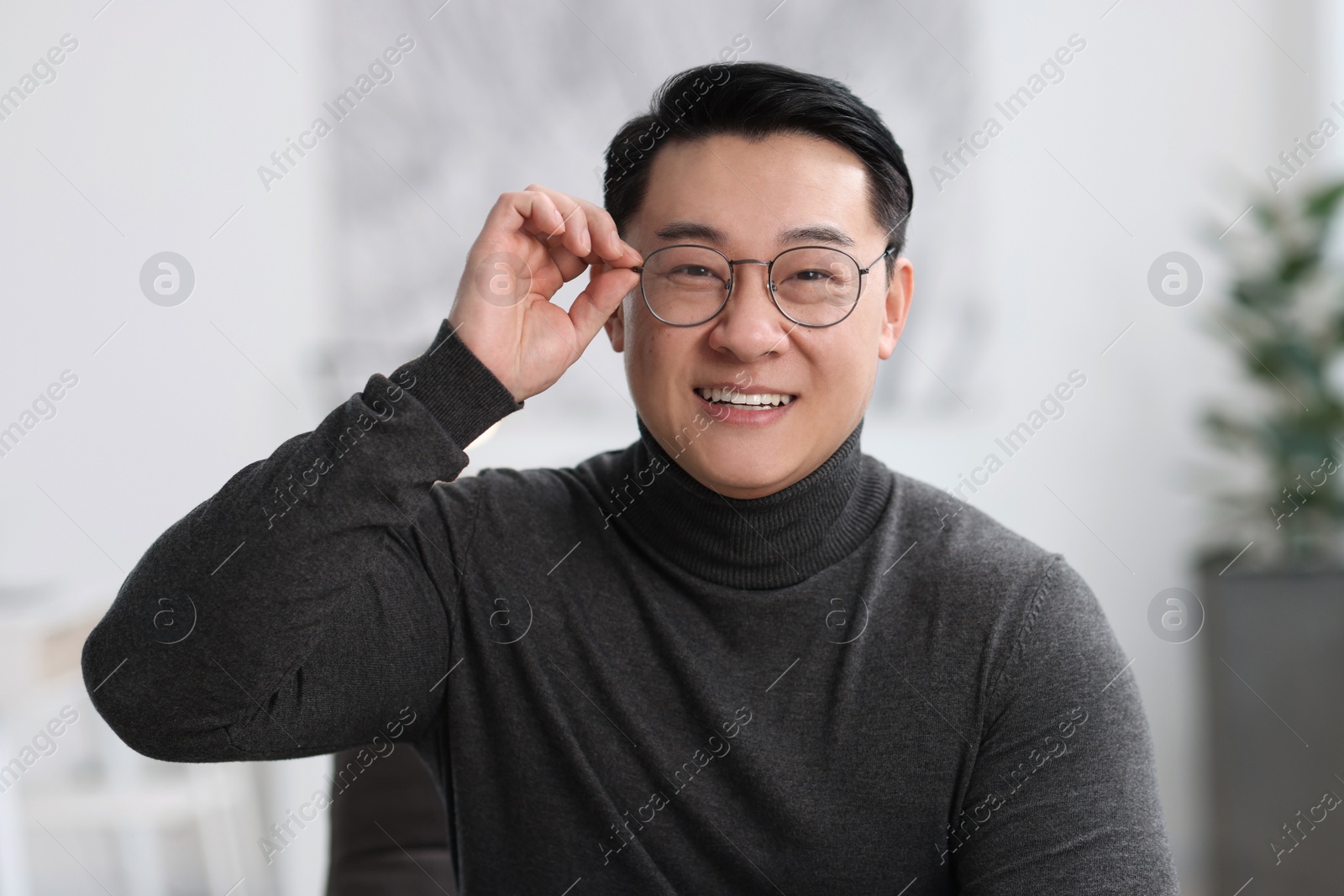 Photo of Portrait of smiling businessman in glasses indoors
