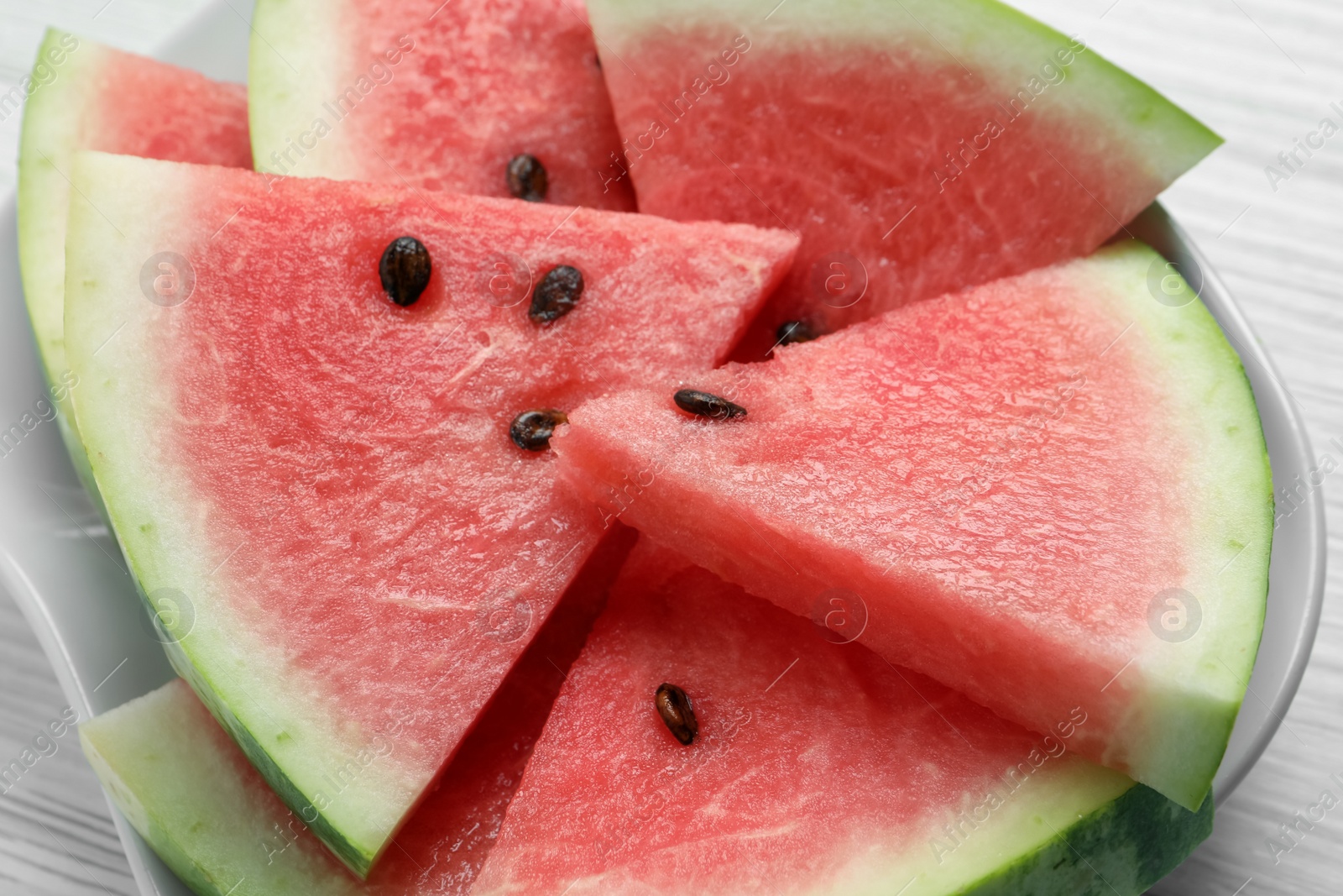 Photo of Delicious fresh watermelon slices on white wooden table, closeup