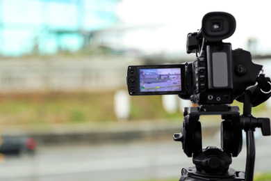 Photo of Professional video camera outdoors. Space for text