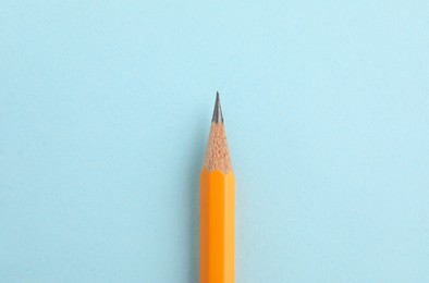 One sharp graphite pencil on light blue background, top view