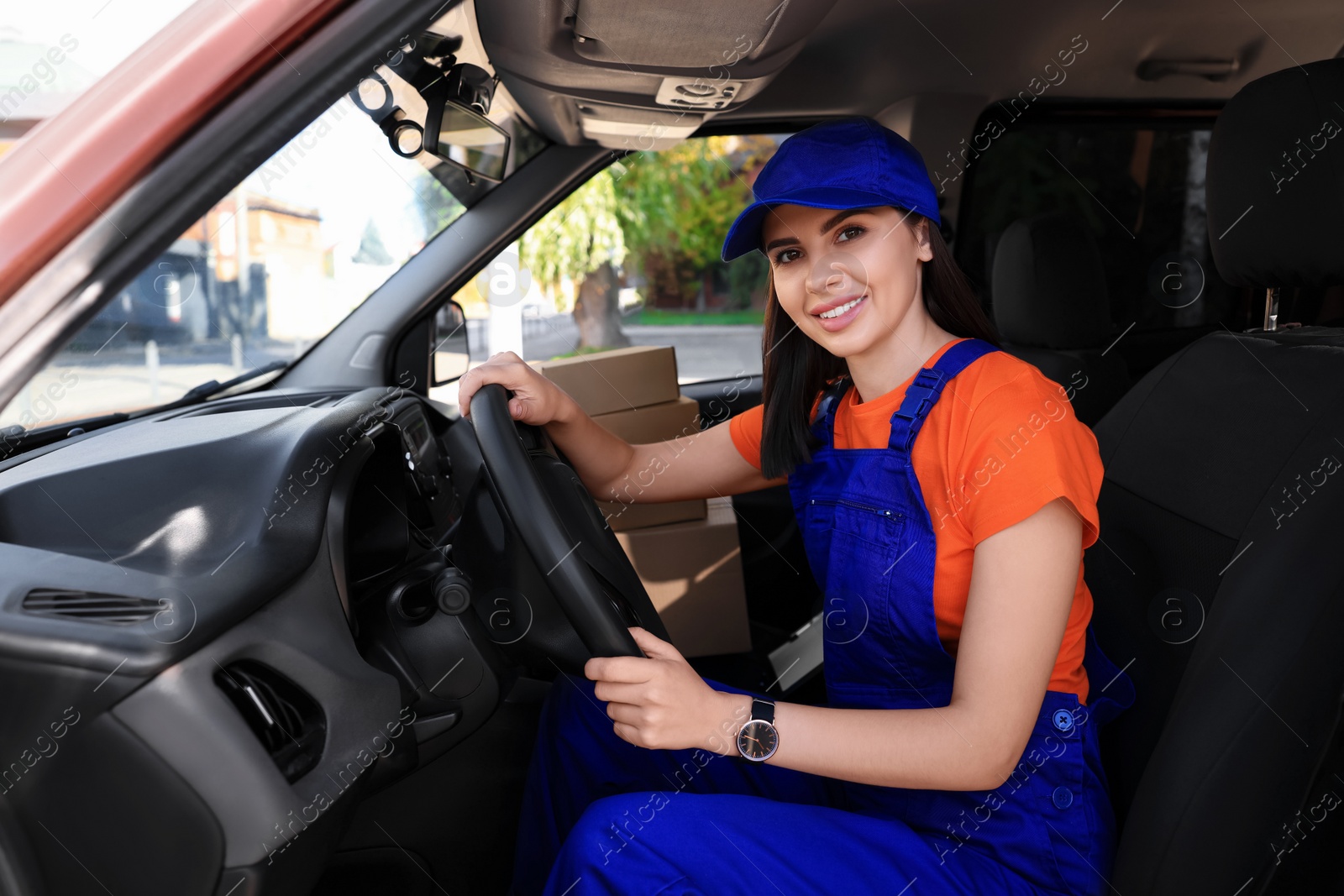 Photo of Courier wearing uniform in car. Delivery service
