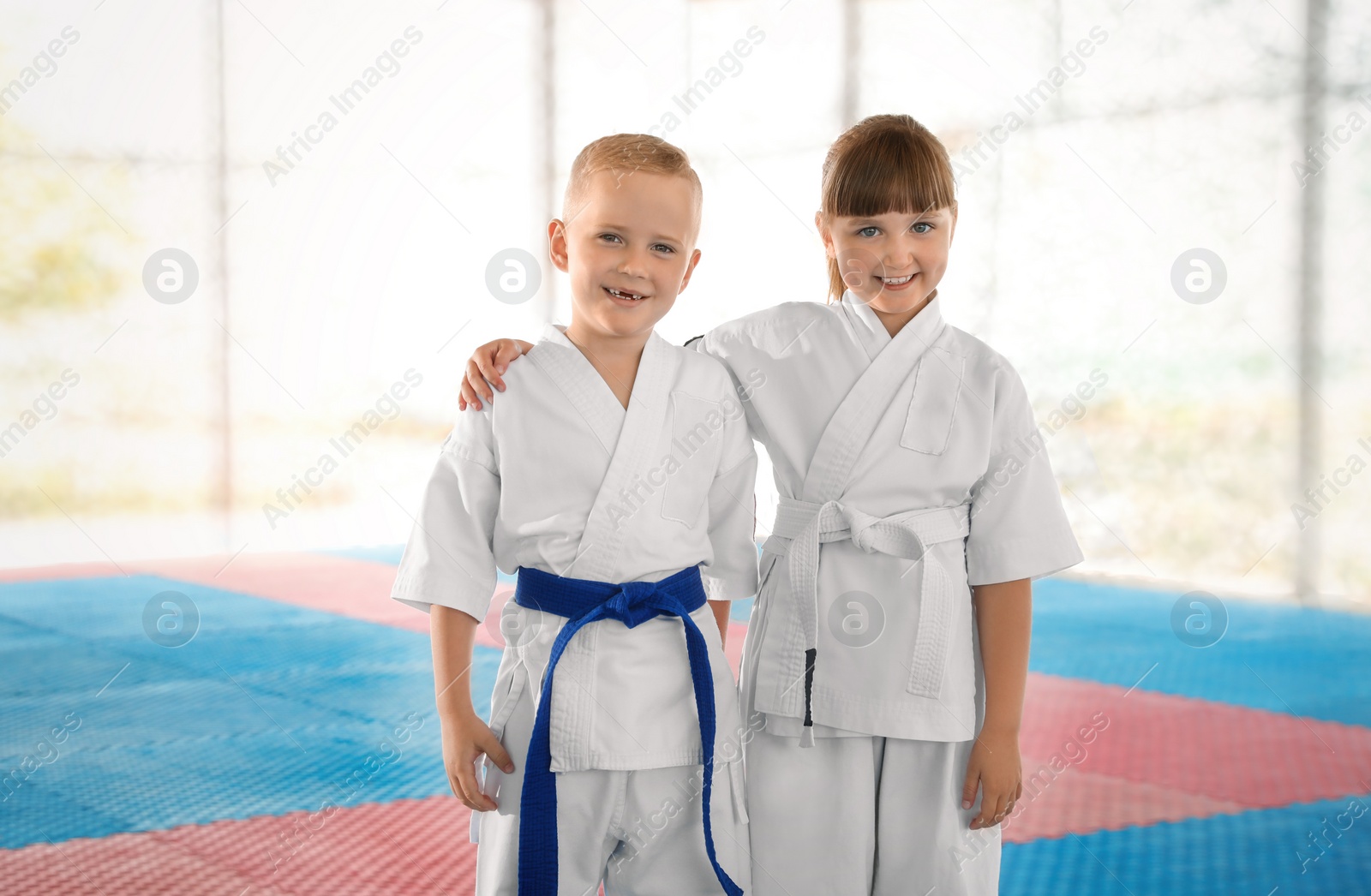 Photo of Children in kimono during karate practice on tatami outdoors